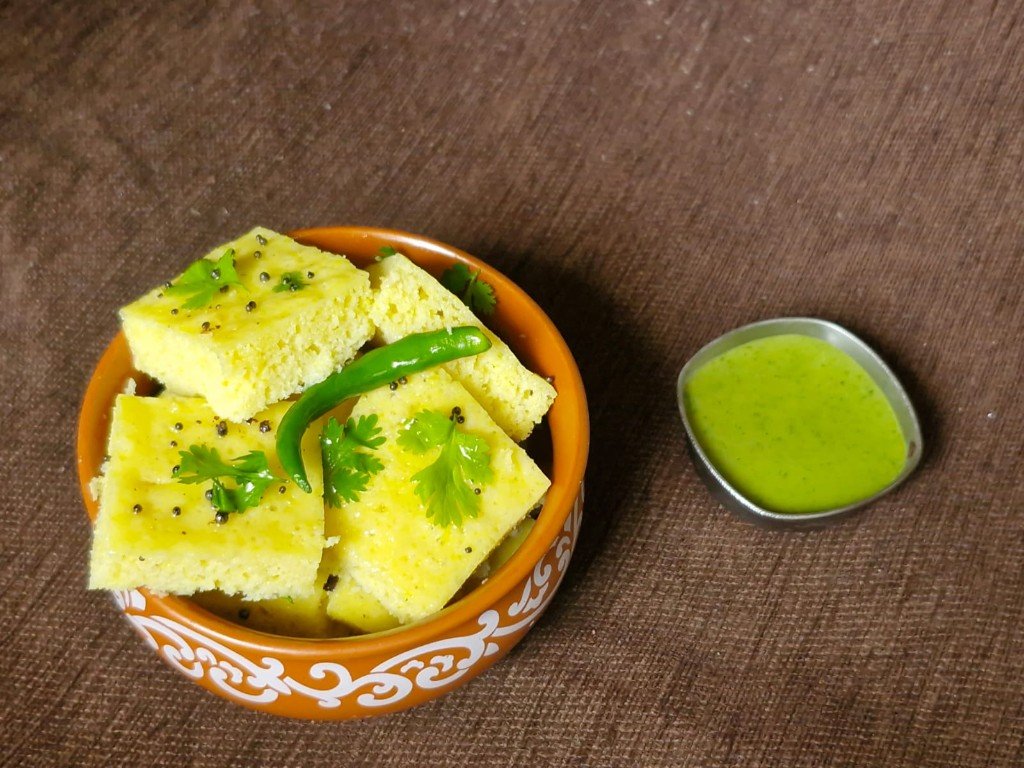 Freshly steamed yellow dhokala with mustard seeds, coriander and green chilli